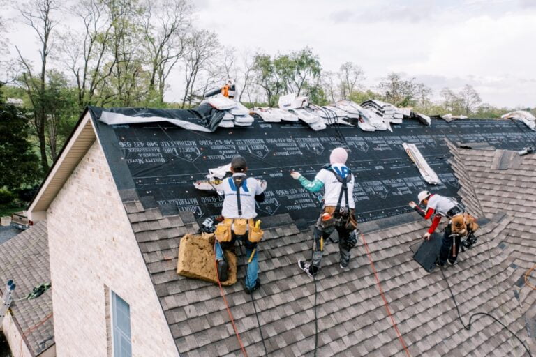 ProLine Roofing crew installing shingles on a pitched roof