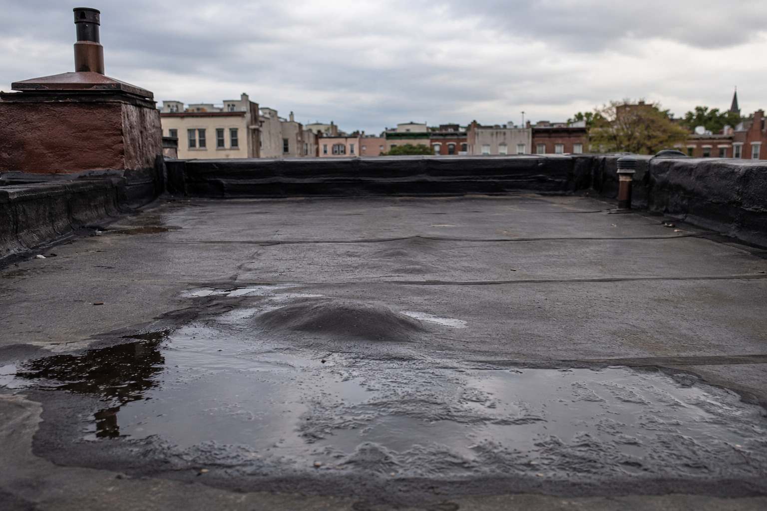 Ponding water and a patched area on a commercial flat roof