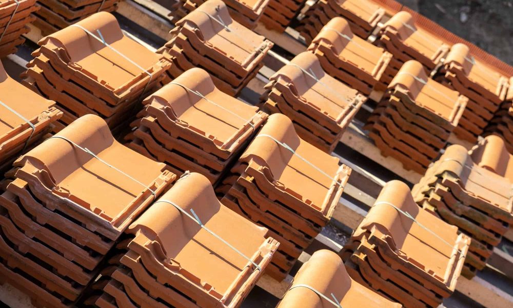 stacks-of-yellow-ceramic-roofing-tiles-for-covering-residential-building-roof-under-construction-.jpg